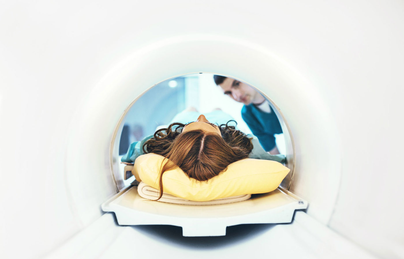 woman enters MRI with head on a pillow