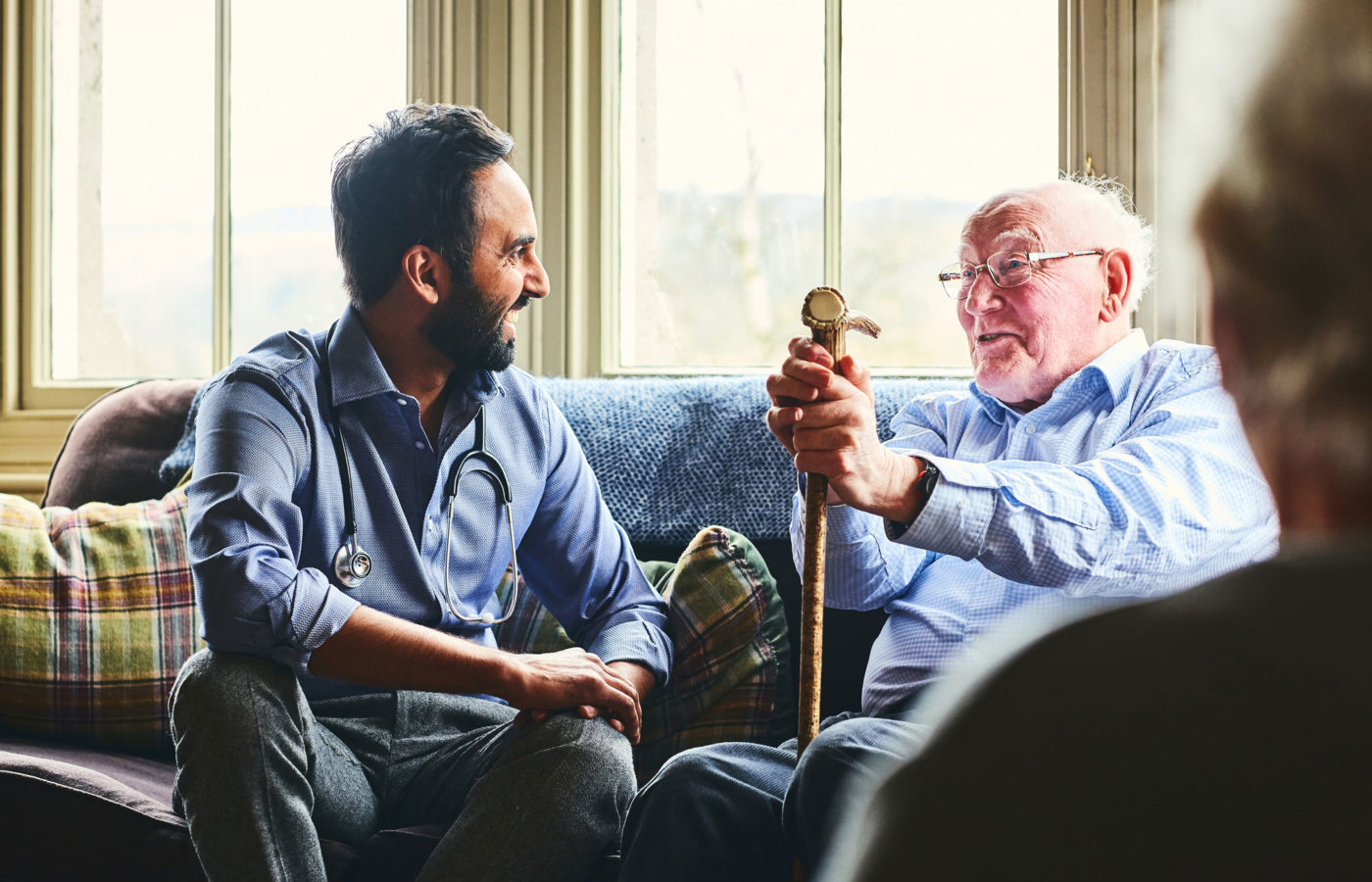 Elderly man and adult male physician talk over custodial care issues