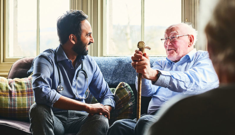 Elderly man and adult male physician talk over custodial care issues