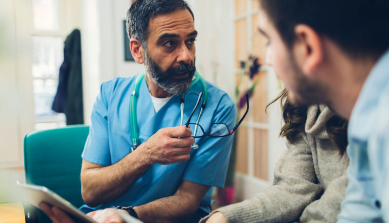 Male doctor discusses care with parents