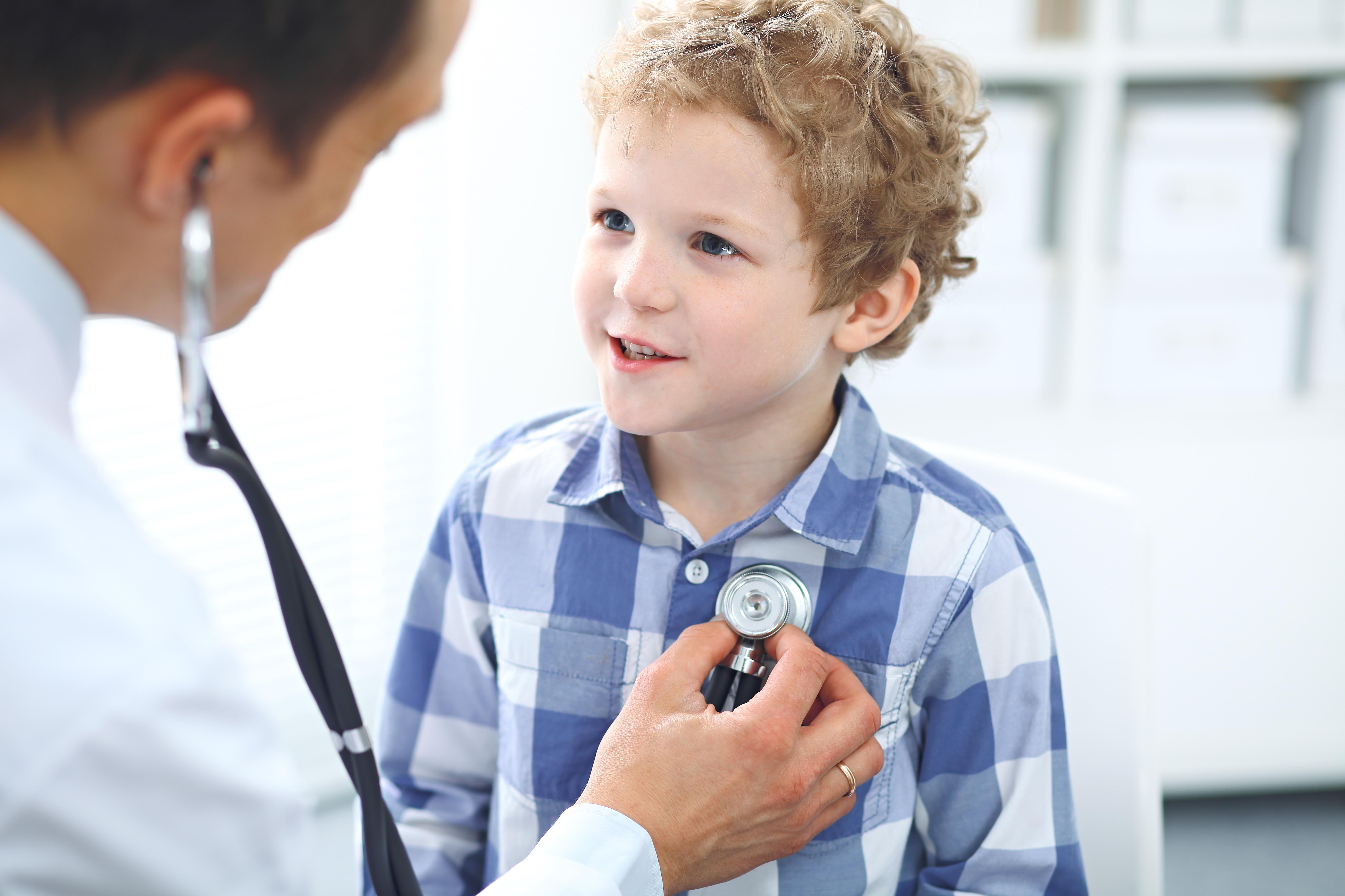 Doctor and child patient. Physician examines little boy by stethoscope. Medicine and children's therapy concept.