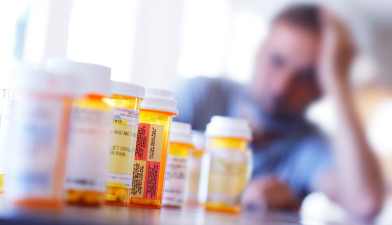 prescription medication with male blurred in the background